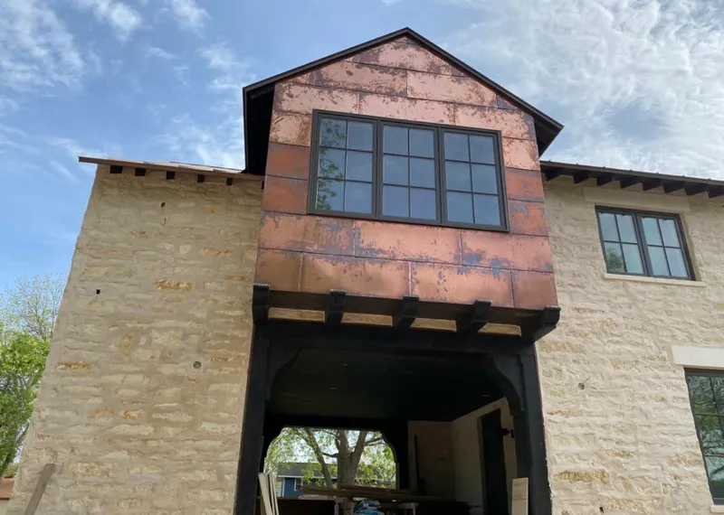 Copper metal panel facade on a stone building for Skylight Installation in Johnston